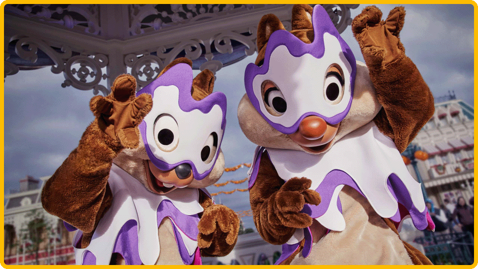 Chip and Dale in purple and white Halloween outfits waving on Main Street
