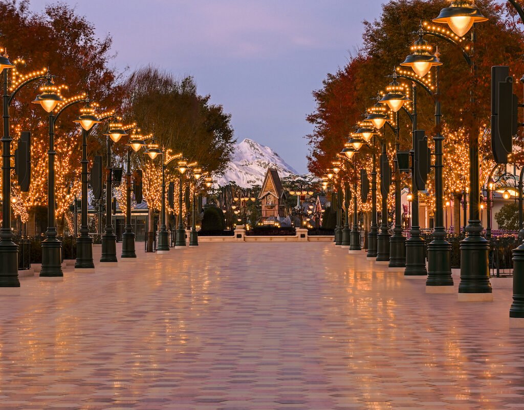 Adventure Way promenade with trees, lamps and mountain backdrop at Disney Adventure World.